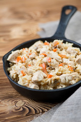 Pilaf with chicken in a cast-iron pan, close-up