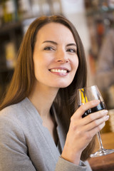 Portrait of pretty young woman drinking red wine in restaurant
