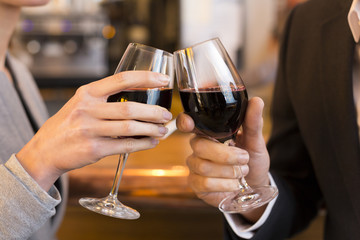 Close Up of Couple Toasting with red wine glass in restaurant