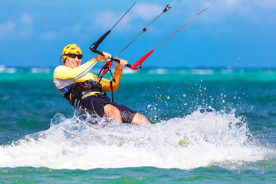young smiling kitesurfer on sea background