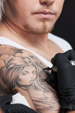 young man getting tattoo on shoulder.