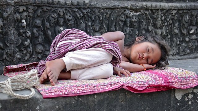young girl sleeping in angkor wat temple, cambodia
