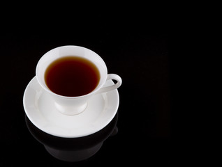A cup of tea over black background