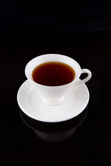 A cup of tea over black background