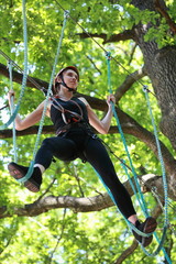 attractive woman climbing in adventure rope park
