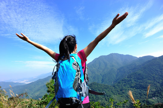 cheering hiking woman enjoy the beautiful view at mountain peak
