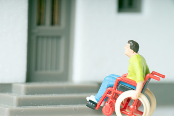 Rollstuhlfahrer vor einem Haus