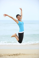 Obraz premium Happy woman jumping on the beach. summer holidays