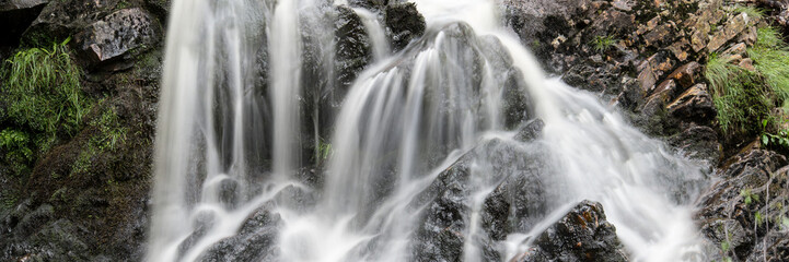 Panorama landscape waterfall detail flowing over rocks in Summer © veneratio