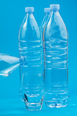 Plastic bottles and a glass on a blue background