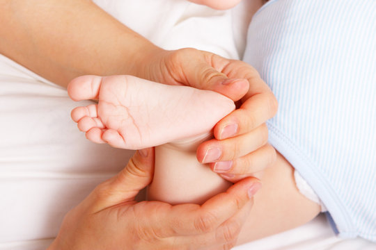 Woman gently holding newborn's foot
