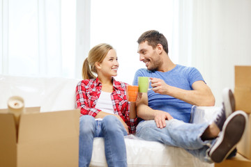 smiling couple relaxing on sofa in new home