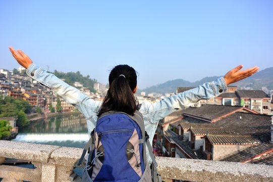 cheering woman tourist open arms at fenghuang ancient town