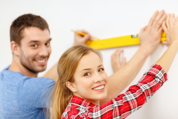 couple building using spirit level to measure