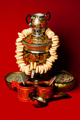 Russian samovar with steering wheels on a red background