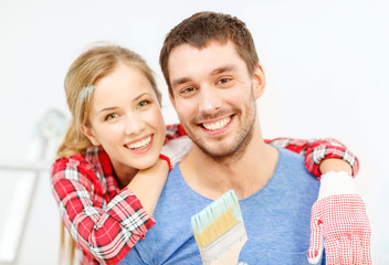 smiling couple covered with paint with paint brush