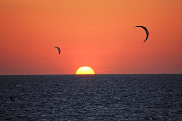 kitesurfers at sunset