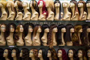 rows of mannequins ina wig shop