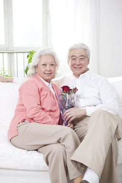 .Senior couple holding a bunch of roses.