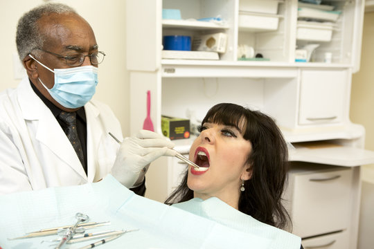 Dentist checking for cavities during oral exam