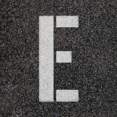 Stencil alphabet letters paint on asphalt road 