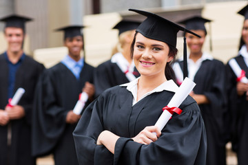 attractive female graduate holding her diploma at ceremony