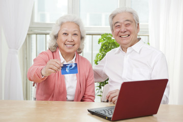 .Senior couple holding credit card.