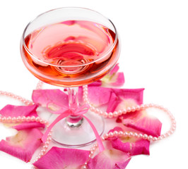 Composition with pink sparkle wine in glass and  rose petals