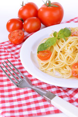 Delicious spaghetti with tomatoes on plate on table close-up