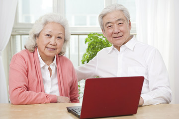 .Portrait of senior couple using laptop.