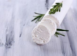 Fototapeta na wymiar Tasty bushe cheese with rosemary, on wooden table