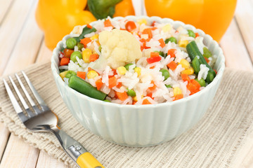 Cooked rice with vegetables on wooden table close up