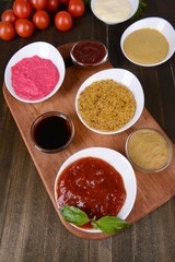 Various sauces on chopping board on table close-up