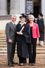 young girl graduate standing with parents