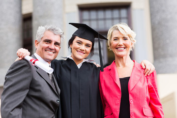 young female graduate with parents