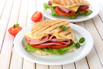 Tasty sandwich with ham on wooden table