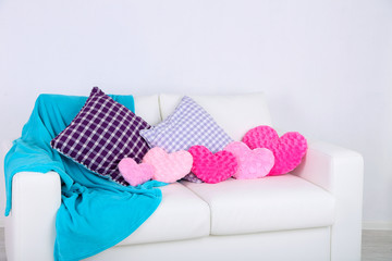 Pink heart shaped pillows, plaid on white sofa