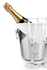 Bottle of champagne in pail and empty glasses, isolated on