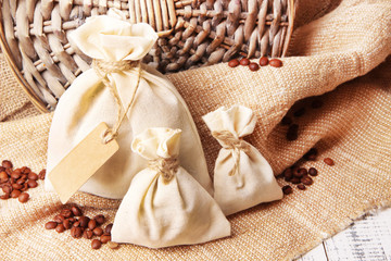 Sacks with coffee beans on wooden table, on sackcloth