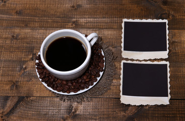 Coffee cup and old blank photos, on wooden background