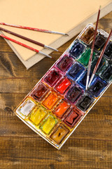 Composition with colorful watercolors, brushes and sketcher