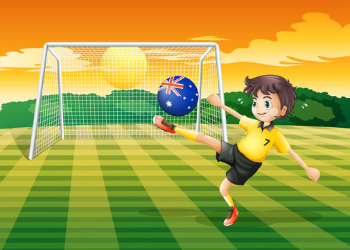A boy kicking the ball with the flag of Australia