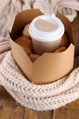 Hot coffee and cookies in box on wooden table close-up