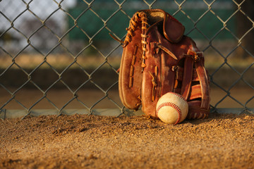 Baseball and Glove against the Fence