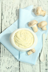 Delicate mushroom sauce in bowl on wooden table close-up