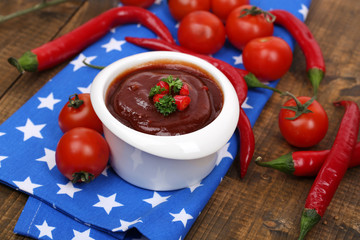 Tomato sauce in bowl on wooden table close-up