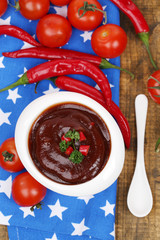 Tomato sauce in bowl on wooden table close-up
