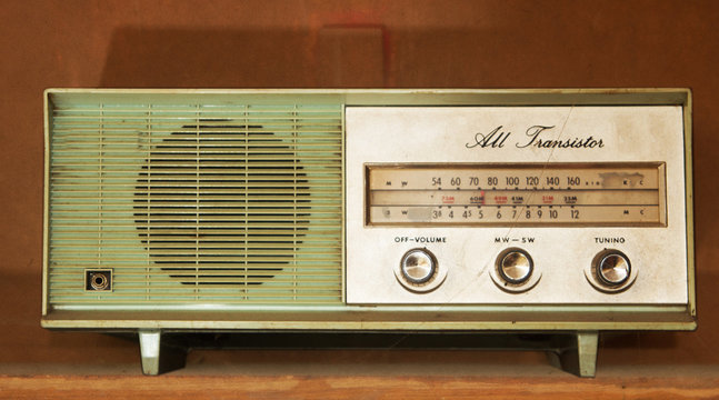 vintage radio on a wooden shelf (toned image )