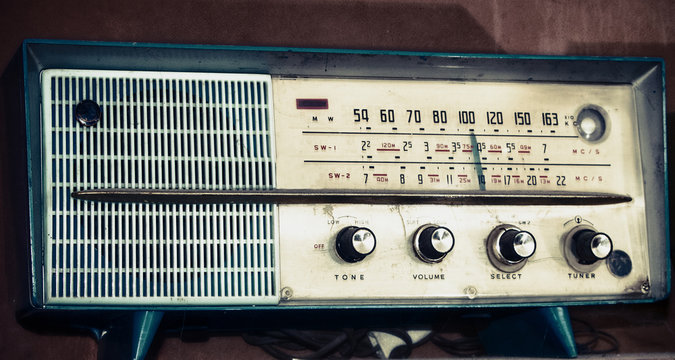 vintage radio on a wooden shelf (toned image )