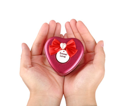 Hands holding red heart shape gift box
